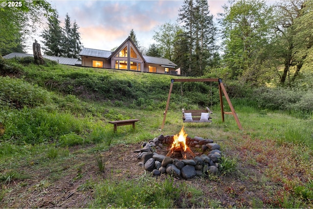 yard at dusk featuring an outdoor fire pit