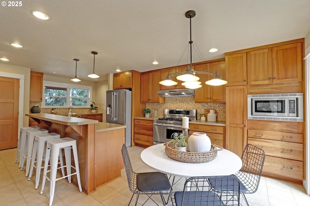 10455 NW Laidlaw Rd, Portland, OR 97229 - kitchen with stainless steel appliances, under cabinet range hood, backsplash, recessed lighting, and light countertops