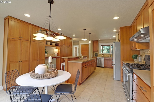 10455 NW Laidlaw Rd, Portland, OR 97229 - kitchen featuring range hood, appliances with stainless steel finishes, a kitchen island, light countertops, and decorative backsplash