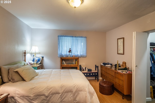 bedroom featuring hardwood / wood-style floors and a textured ceiling