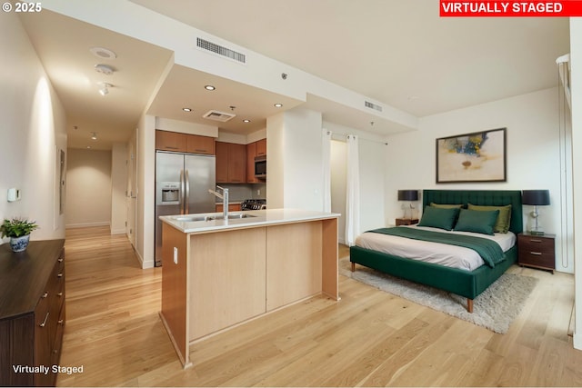 1260 NW Naito Pkwy Unit 200B, Portland, OR 97209 - kitchen featuring light wood-type flooring, baseboards, brown cabinetry, light countertops, and appliances with stainless steel finishes