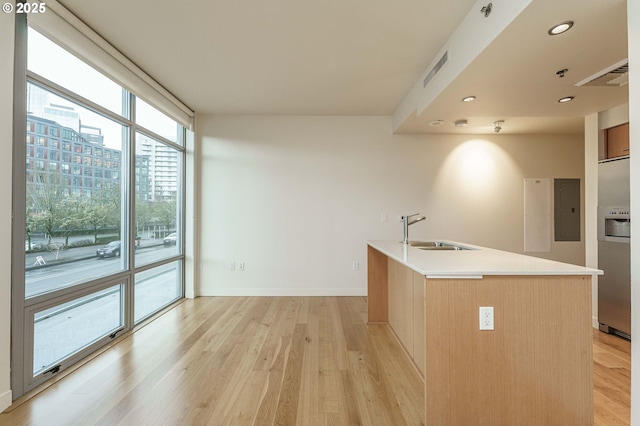 1260 NW Naito Pkwy Unit 200B, Portland, OR 97209 - bedroom featuring light wood-style flooring, a sink, stainless steel fridge, baseboards, and recessed lighting
