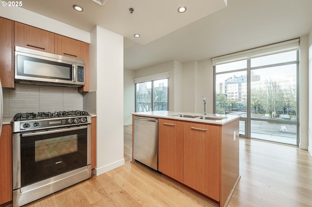 1260 NW Naito Pkwy Unit 200B, Portland, OR 97209 - kitchen featuring stainless steel appliances, brown cabinetry, light countertops, decorative backsplash, and light wood-style flooring