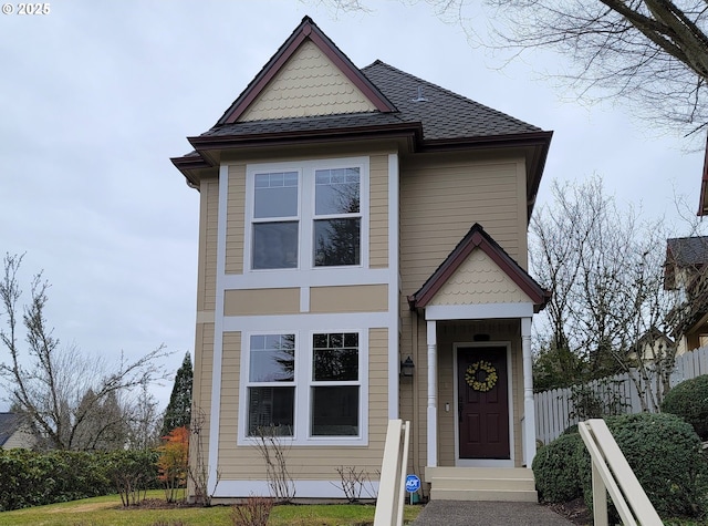 view of front of property with fence and roof with shingles