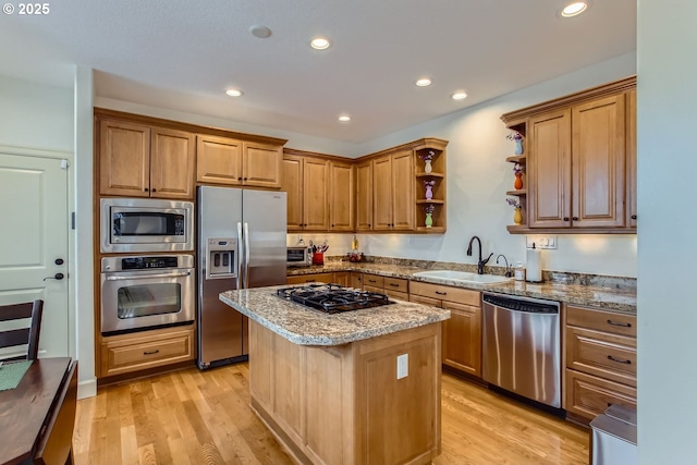 kitchen featuring stainless steel appliances, a kitchen island, light hardwood / wood-style floors, sink, and light stone counters