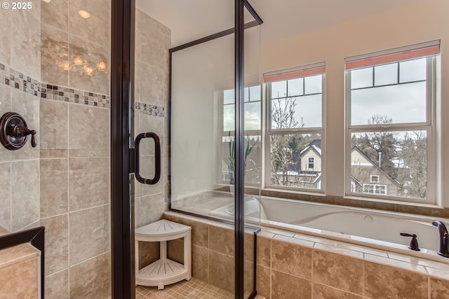 bathroom featuring plenty of natural light and independent shower and bath