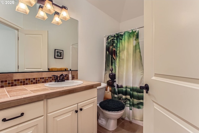 bathroom featuring vanity, walk in shower, tile patterned flooring, toilet, and tasteful backsplash