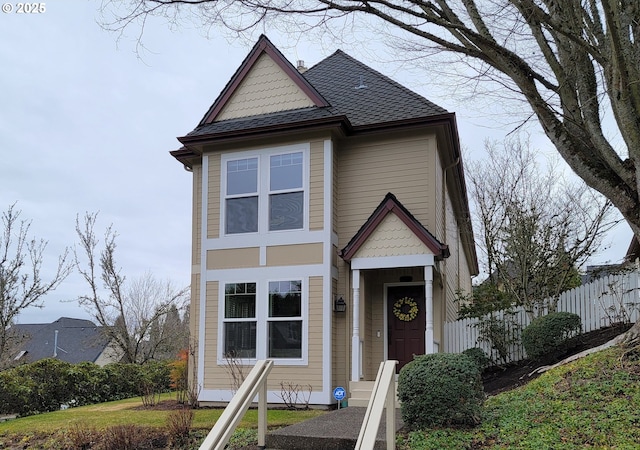 view of front of home featuring a shingled roof and fence