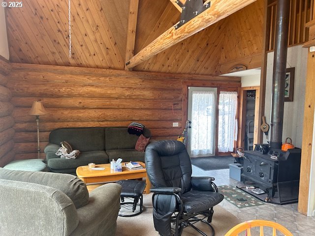 living room featuring wooden ceiling, beam ceiling, high vaulted ceiling, and a wood stove