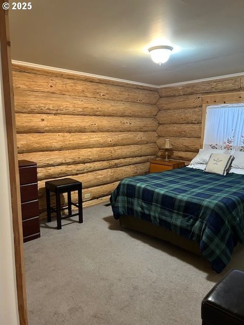 carpeted bedroom with crown molding and log walls