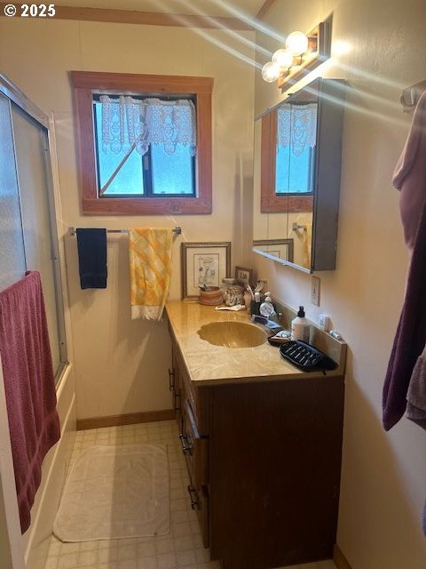 bathroom featuring vanity, shower / bath combination with glass door, and vaulted ceiling