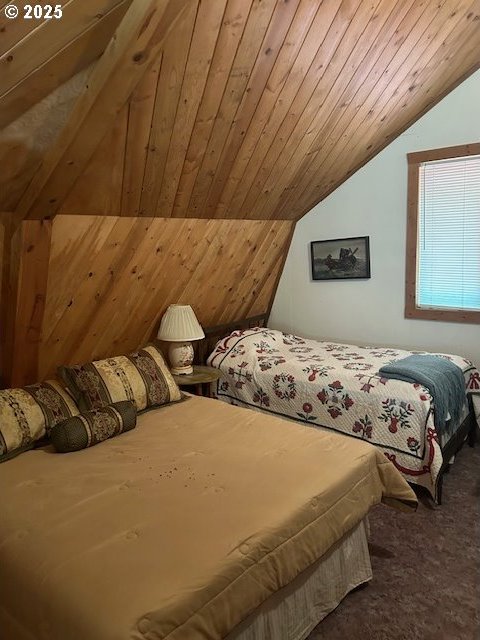 bedroom with carpet, lofted ceiling, and wood ceiling