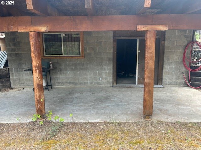 view of exterior entry with a patio area