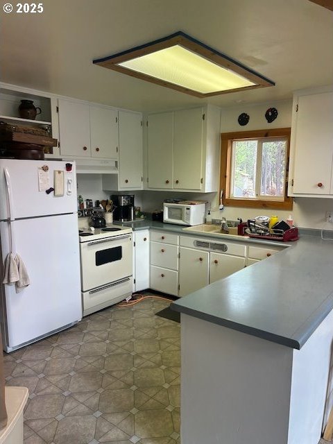 kitchen featuring white cabinetry, white appliances, and kitchen peninsula