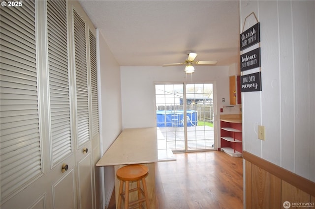 dining space with a ceiling fan and wood finished floors