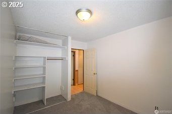 unfurnished bedroom featuring a closet and dark carpet