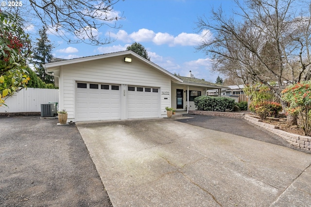 ranch-style house with an attached garage, fence, central AC unit, and concrete driveway