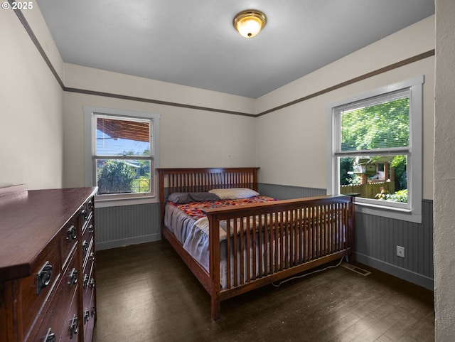 682 S Settlemier Ave, Woodburn, OR 97071 - bedroom featuring wood-type flooring, a wainscoted wall, multiple windows, and baseboards