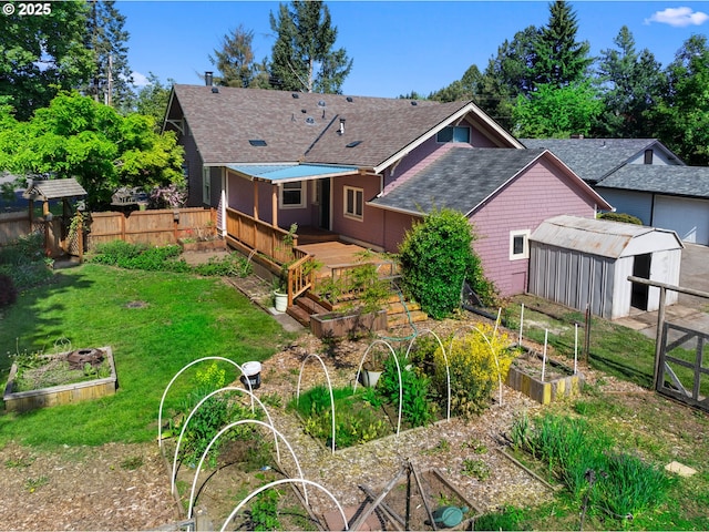682 S Settlemier Ave, Woodburn, OR 97071 - rear view of property featuring a garden, a shingled roof, and an outbuilding