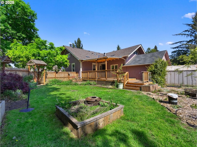 682 S Settlemier Ave, Woodburn, OR 97071 - rear view of house with a wooden deck and a vegetable garden