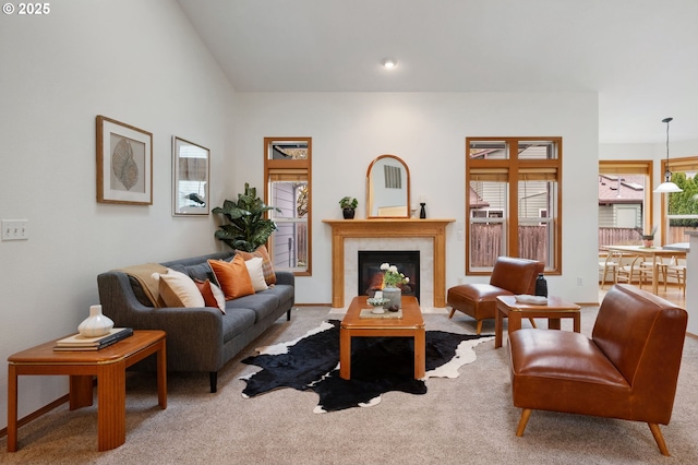 carpeted living area featuring a tile fireplace