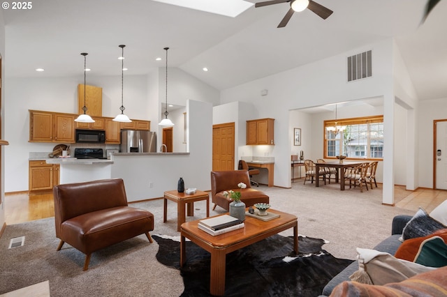 living room featuring light colored carpet, ceiling fan with notable chandelier, visible vents, and high vaulted ceiling