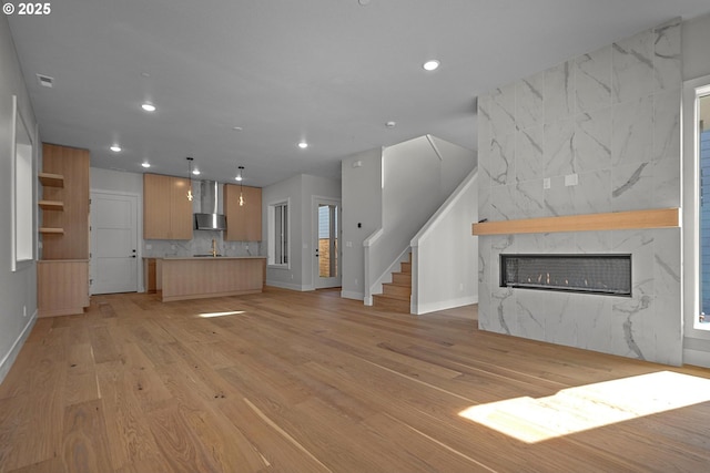 unfurnished living room with a fireplace and light wood-type flooring