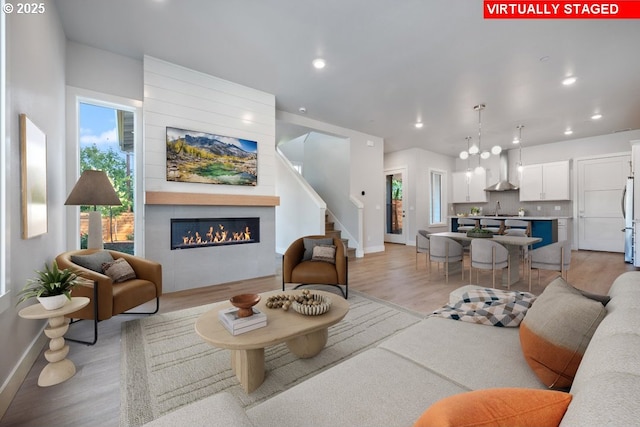 living room featuring a fireplace, sink, and light hardwood / wood-style flooring