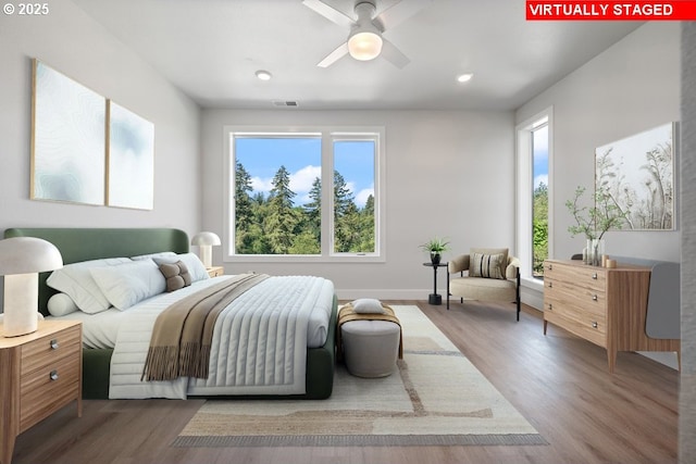 bedroom with multiple windows and hardwood / wood-style flooring