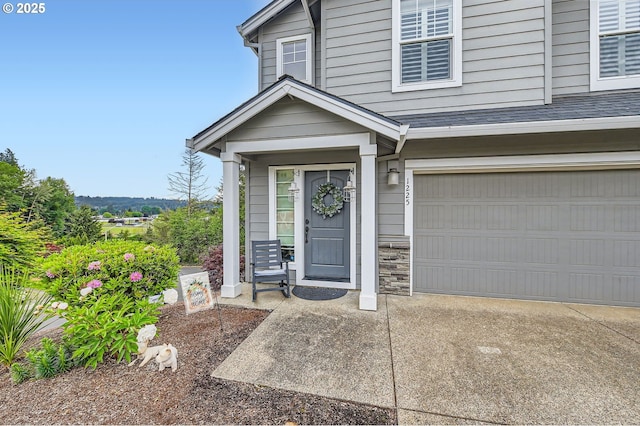 1225 NE Rockwell Dr, Estacada, OR 97023 - view of exterior entry with an attached garage, stone siding, and concrete driveway