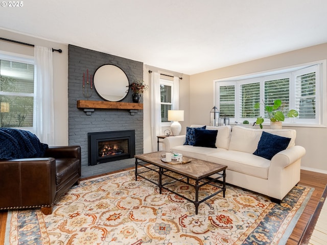 living area featuring light wood-type flooring, a fireplace, and baseboards