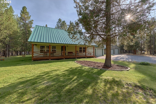 rear view of house with a porch, a lawn, and metal roof