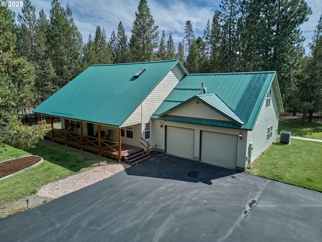 view of front of property with covered porch, central air condition unit, an attached garage, asphalt driveway, and a front lawn