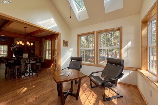 living area featuring a chandelier, wood finished floors, plenty of natural light, and a skylight