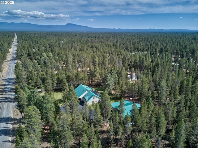 bird's eye view of a heavily wooded area and a mountainous background