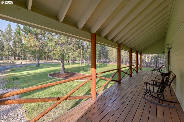 wooden deck featuring a lawn and view of scattered trees