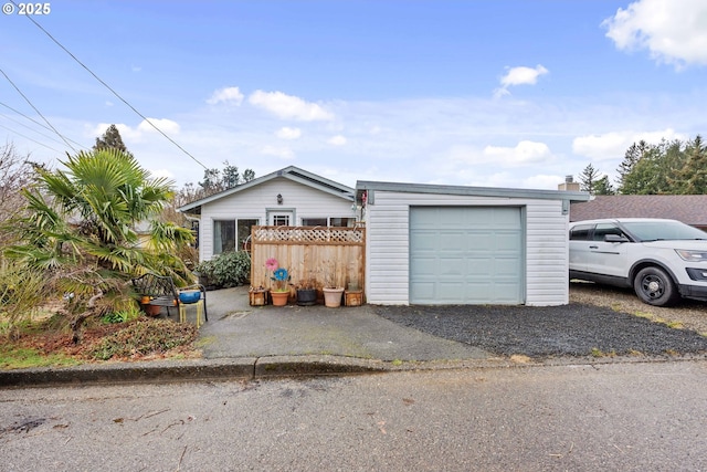 exterior space featuring a garage, an outdoor structure, and fence