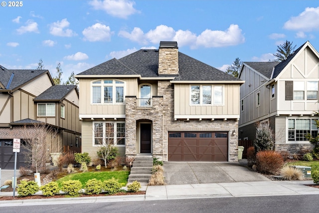 view of front of home featuring driveway, a chimney, roof with shingles, an attached garage, and board and batten siding