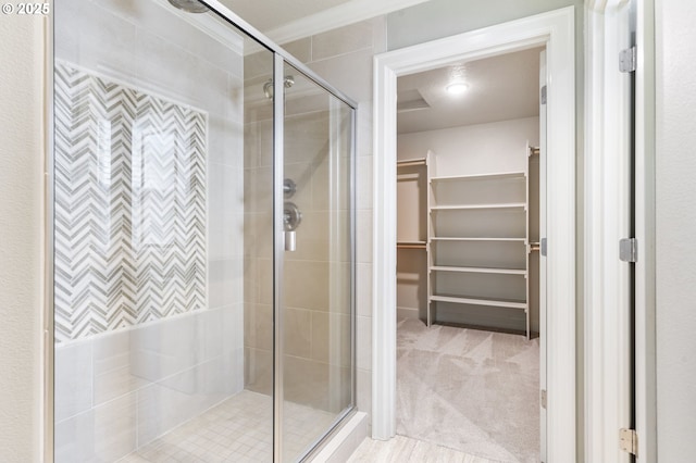 bathroom featuring a stall shower, crown molding, and a spacious closet