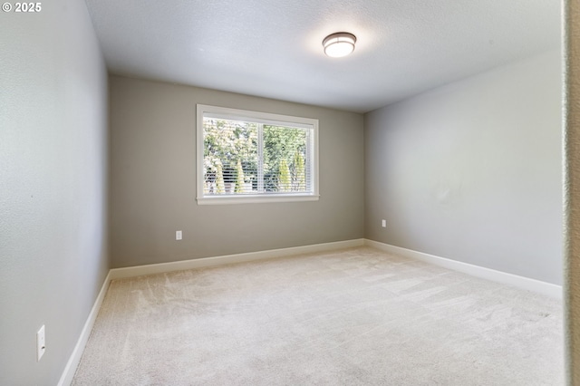 unfurnished room with a textured ceiling, carpet, and baseboards