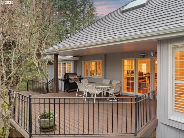 deck at dusk with area for grilling and outdoor dining space