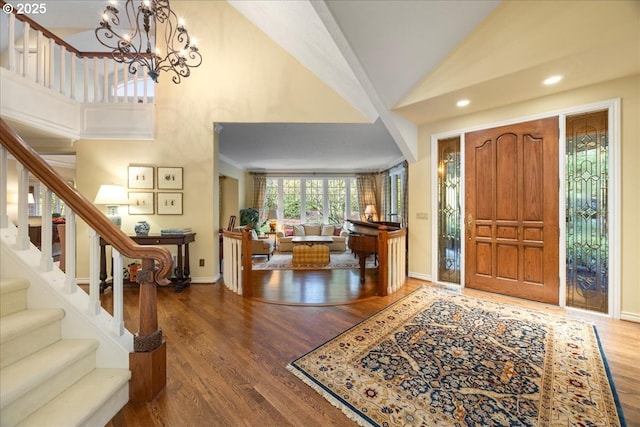 entrance foyer featuring baseboards, stairway, recessed lighting, wood finished floors, and high vaulted ceiling