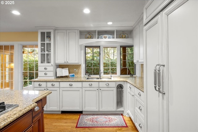 kitchen with white cabinetry, sink, a wealth of natural light, and light hardwood / wood-style flooring