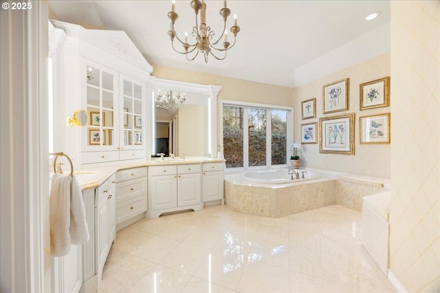 bathroom featuring tile patterned floors, vanity, a relaxing tiled tub, and a notable chandelier