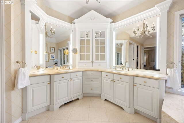 bathroom with tile patterned flooring, vanity, an inviting chandelier, and lofted ceiling