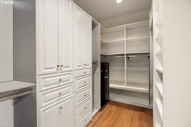 walk in closet with light hardwood / wood-style floors