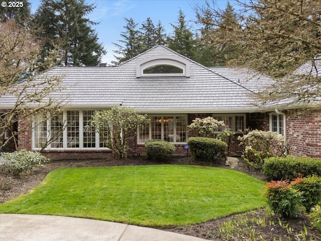 view of front facade with brick siding and a front lawn