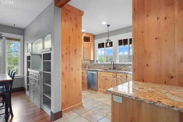 kitchen with sink, light stone counters, light brown cabinetry, decorative backsplash, and stainless steel dishwasher