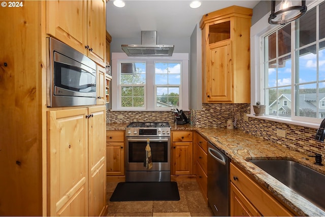 kitchen with light stone counters, sink, decorative backsplash, and stainless steel appliances