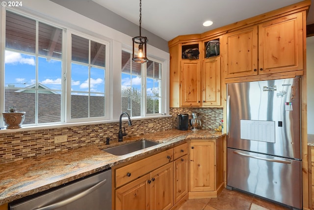 kitchen featuring sink, tasteful backsplash, decorative light fixtures, appliances with stainless steel finishes, and light stone countertops